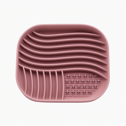 Pink silicone mat with textured surface on a white background