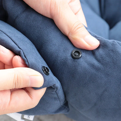 Close-up of a person buttoning a blue garment with black buttons.