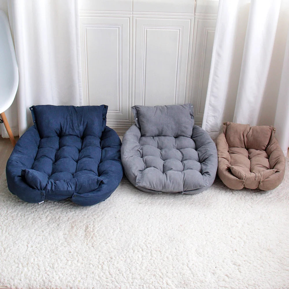 Three cushioned pet beds in blue, gray, and brown on a carpeted floor.