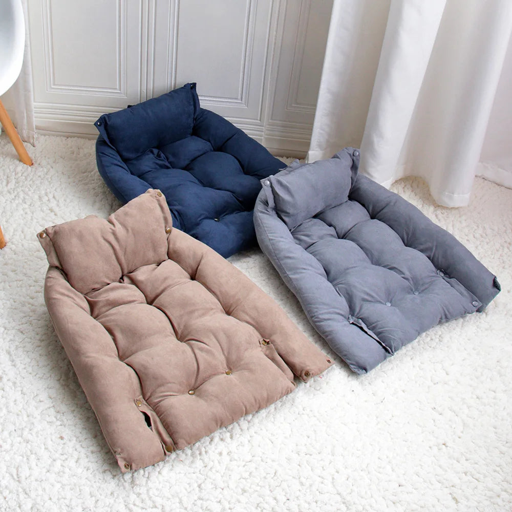 Three cushioned pet beds in blue, pink, and gray on a white carpet.