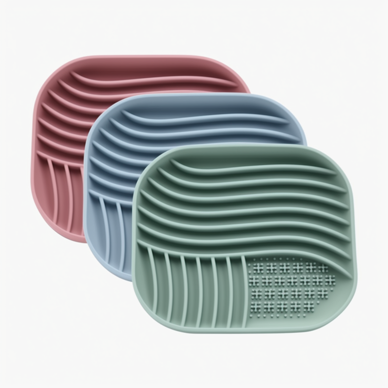 Three silicone mat with textured surface in pink, blue, and green on a white background