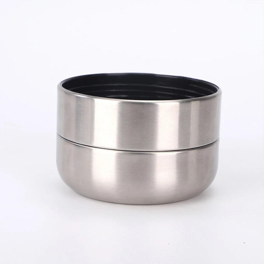 Stainless steel container with black lid on a white background